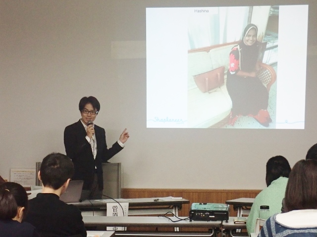 ハシナ(スクリーン内の女性)の話をする菅原