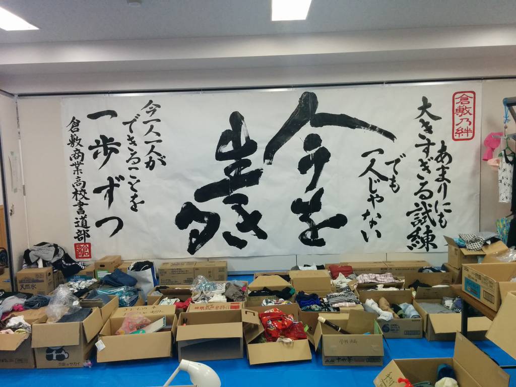 箭田分館に広げられた支援物資。高校生から贈られた書が飾られていました