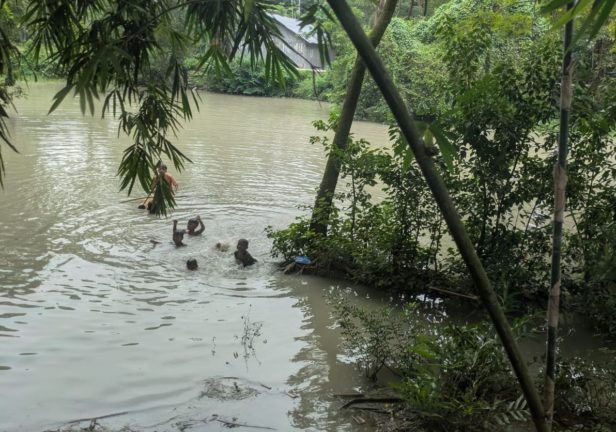 池で水遊びをする村の子どもたち